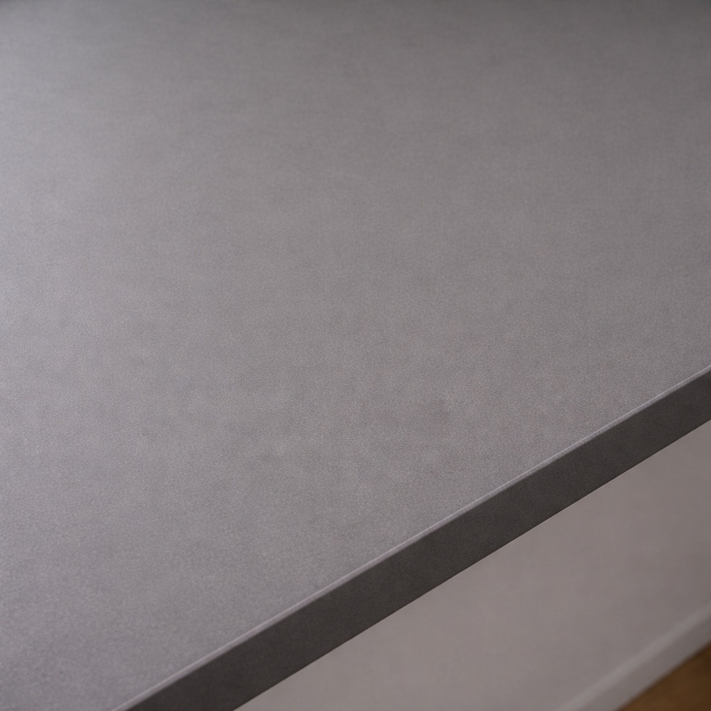 Appui de fenêtre en mélaminé aspect pierre ardoise gris foncé, gros plan de la surface finement structurée