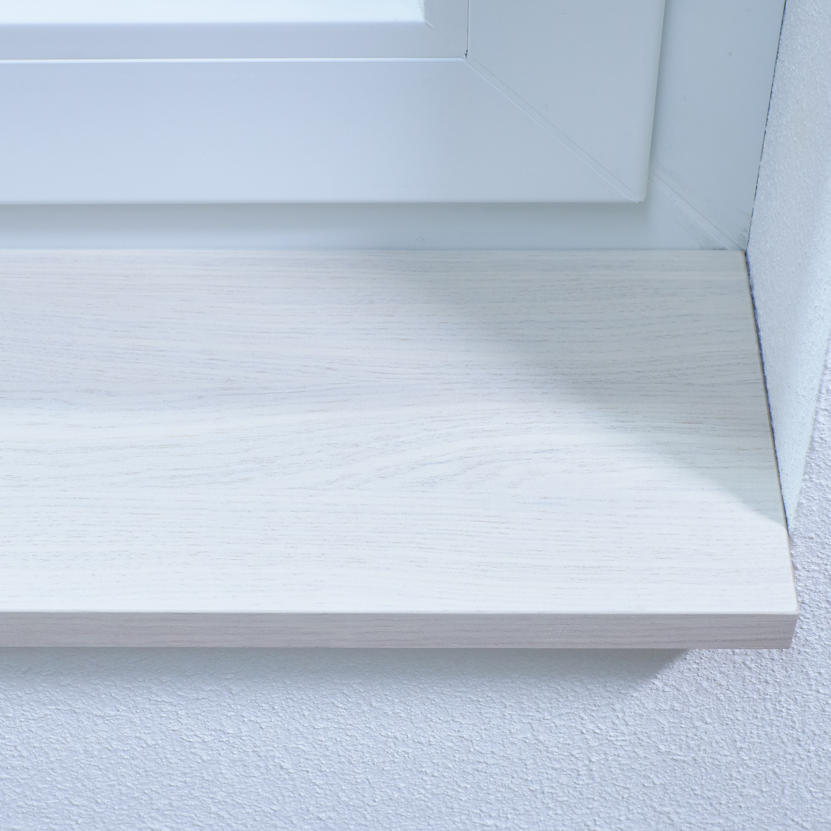 Appui de fenêtre en chêne teinté blanc, gros plan du chant avant avec veinage du chêne visible par transparence