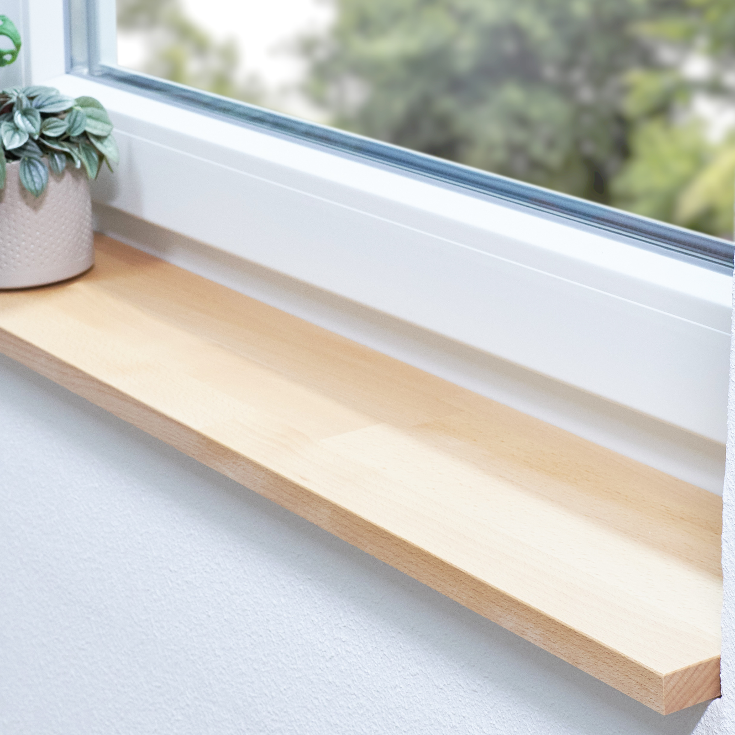 Appui de fenêtre en hêtre naturel abouté sur mesure, appui clair en bois massif dans une niche devant une fenêtre blanche