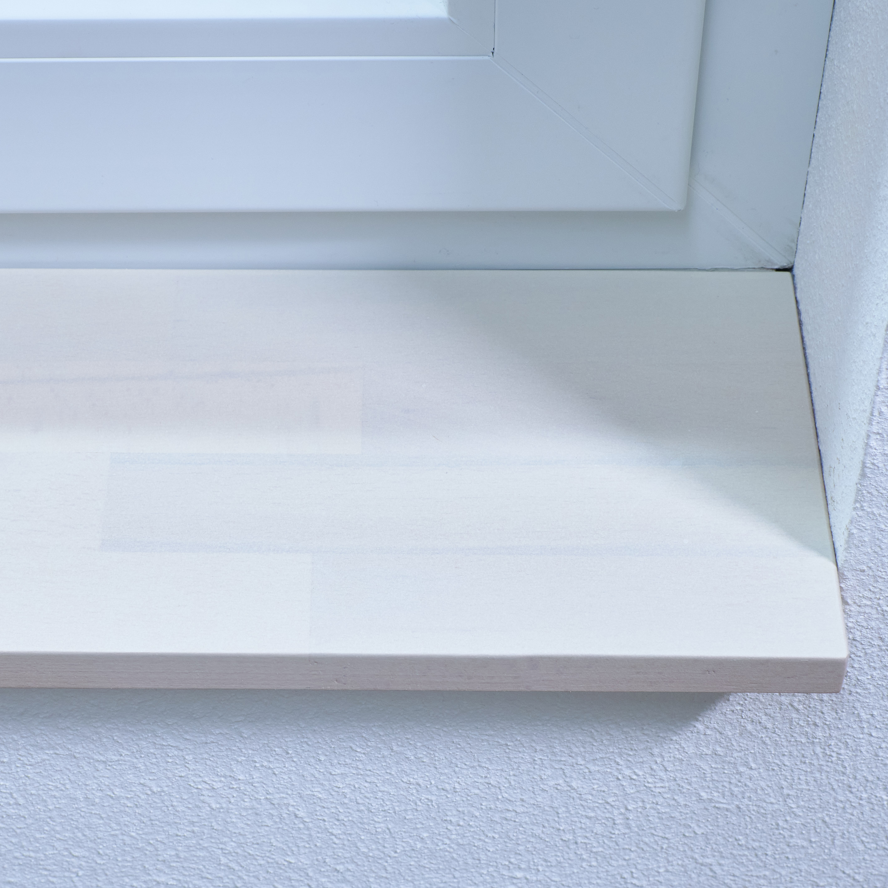 Appui de fenêtre en hêtre à cœur rouge teinté blanc, abouté, gros plan du chant avant avec joints des lamelles visibles