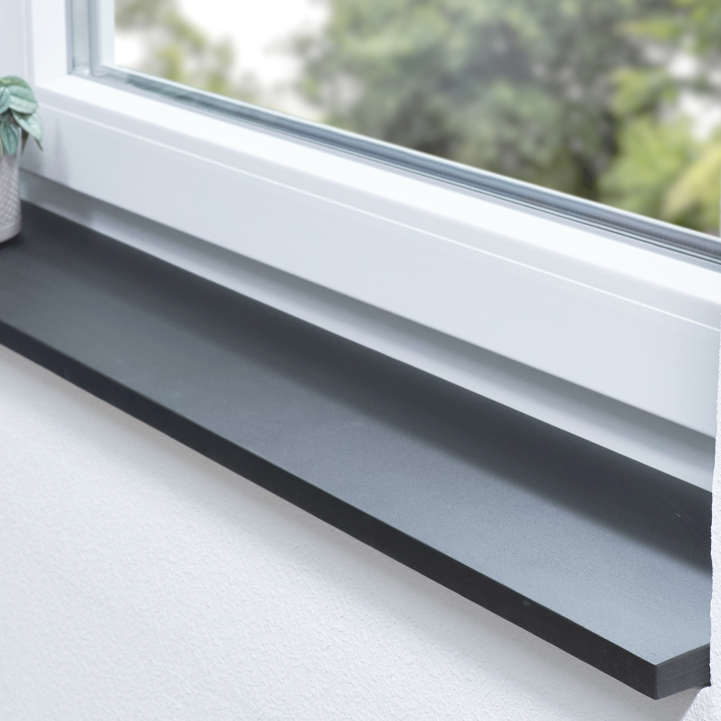 Appui de fenêtre en hêtre teinté noir sur mesure, appui foncé dans une niche devant une fenêtre blanche avec plante verte