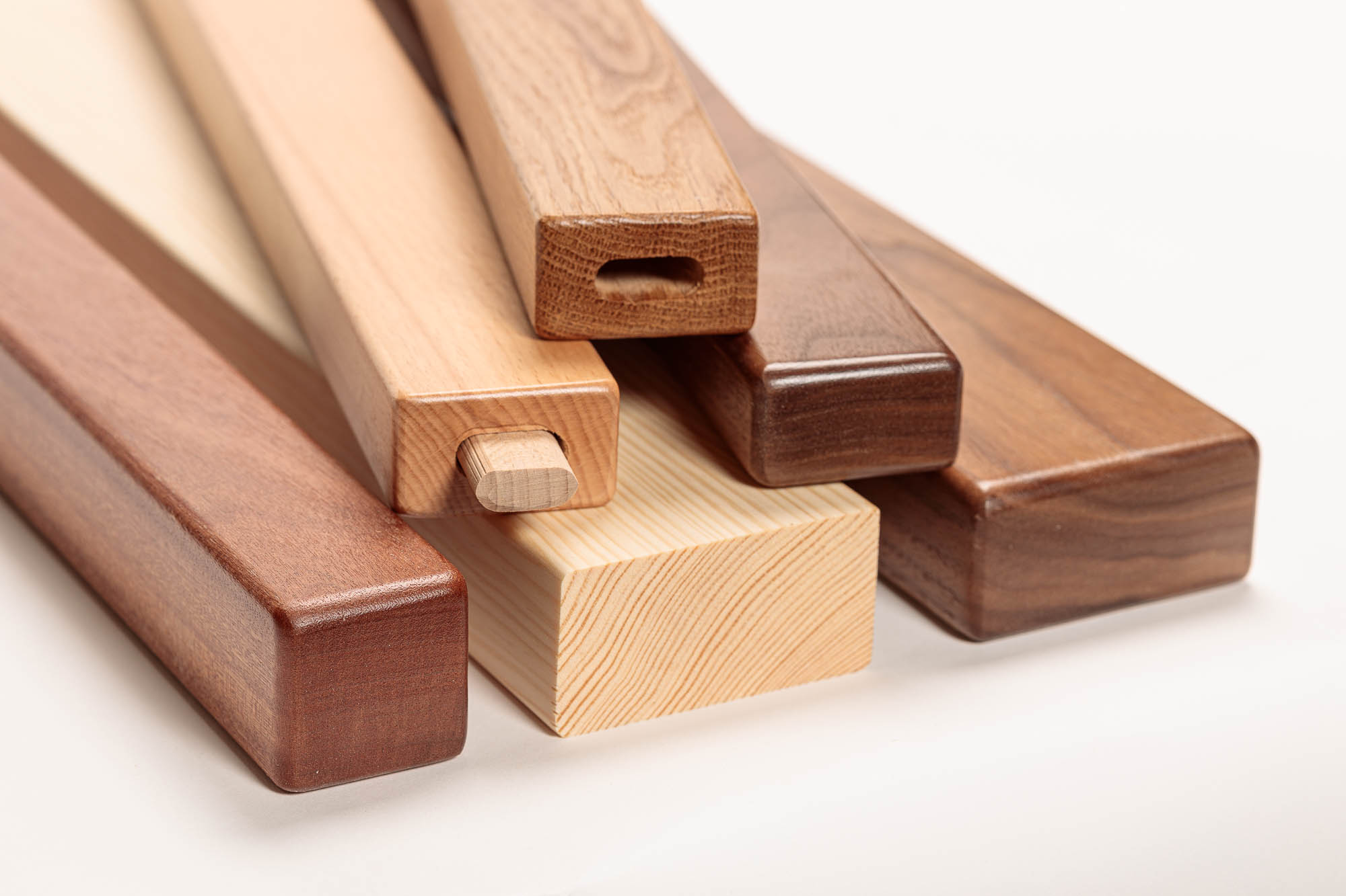 Mains courantes rectangulaires en bois de différentes essences empilées, un profil avec raccord en bois, gros plan des bouts