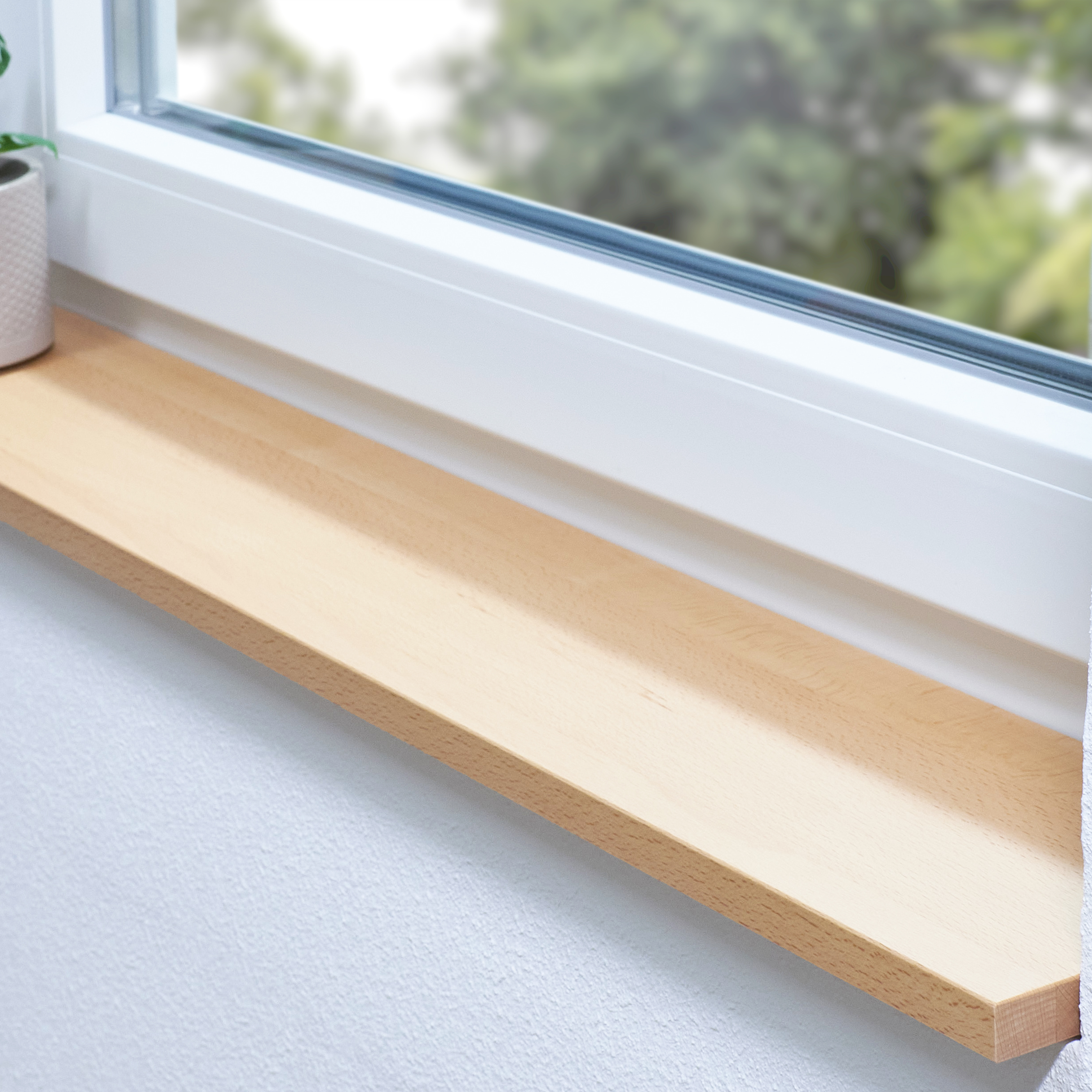 Appui de fenêtre en hêtre naturel sur mesure, appui clair en bois massif dans une niche devant une fenêtre blanche, plante
