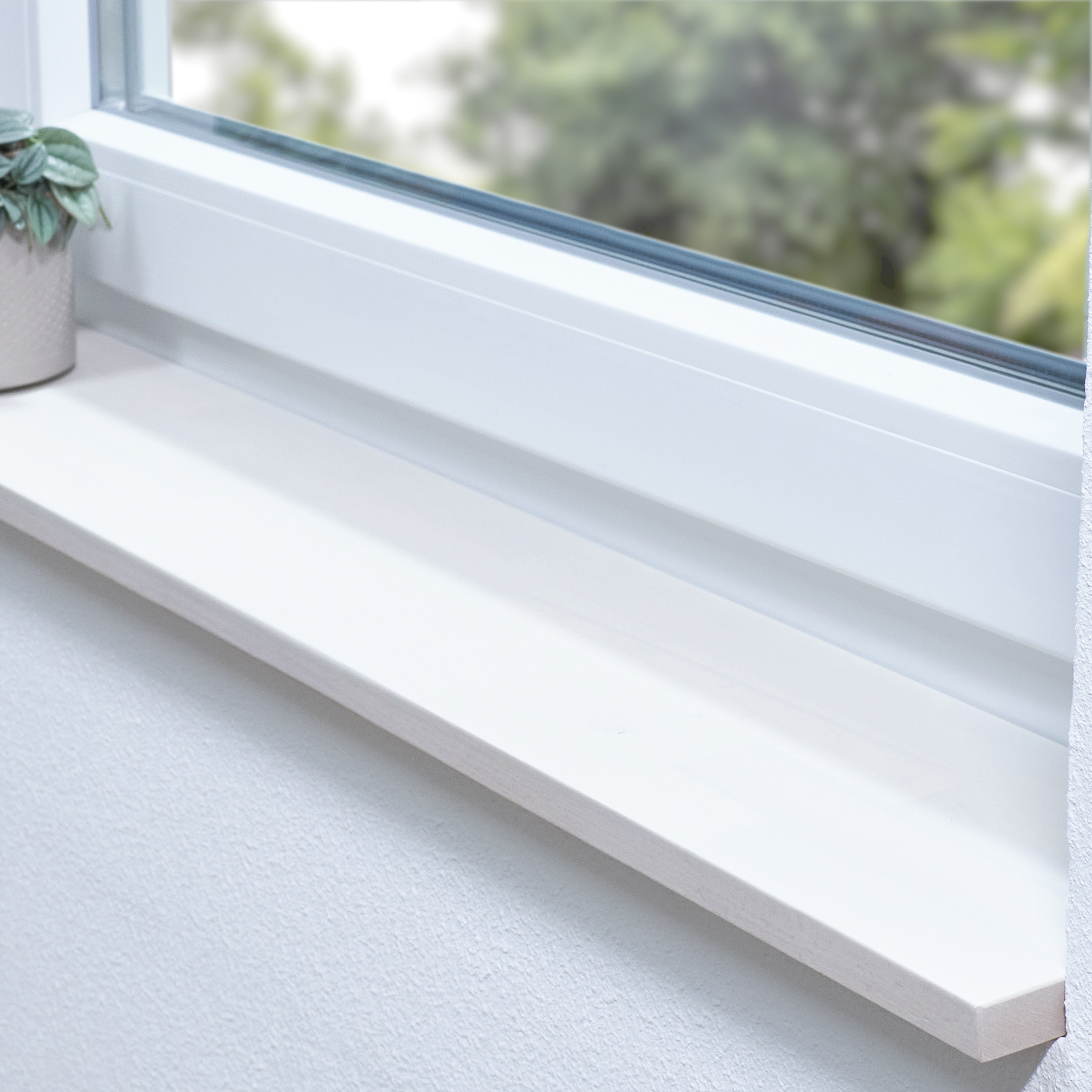 Appui de fenêtre en hêtre à cœur rouge teinté blanc, abouté, dans une embrasure blanche avec plante et vue sur la verdure