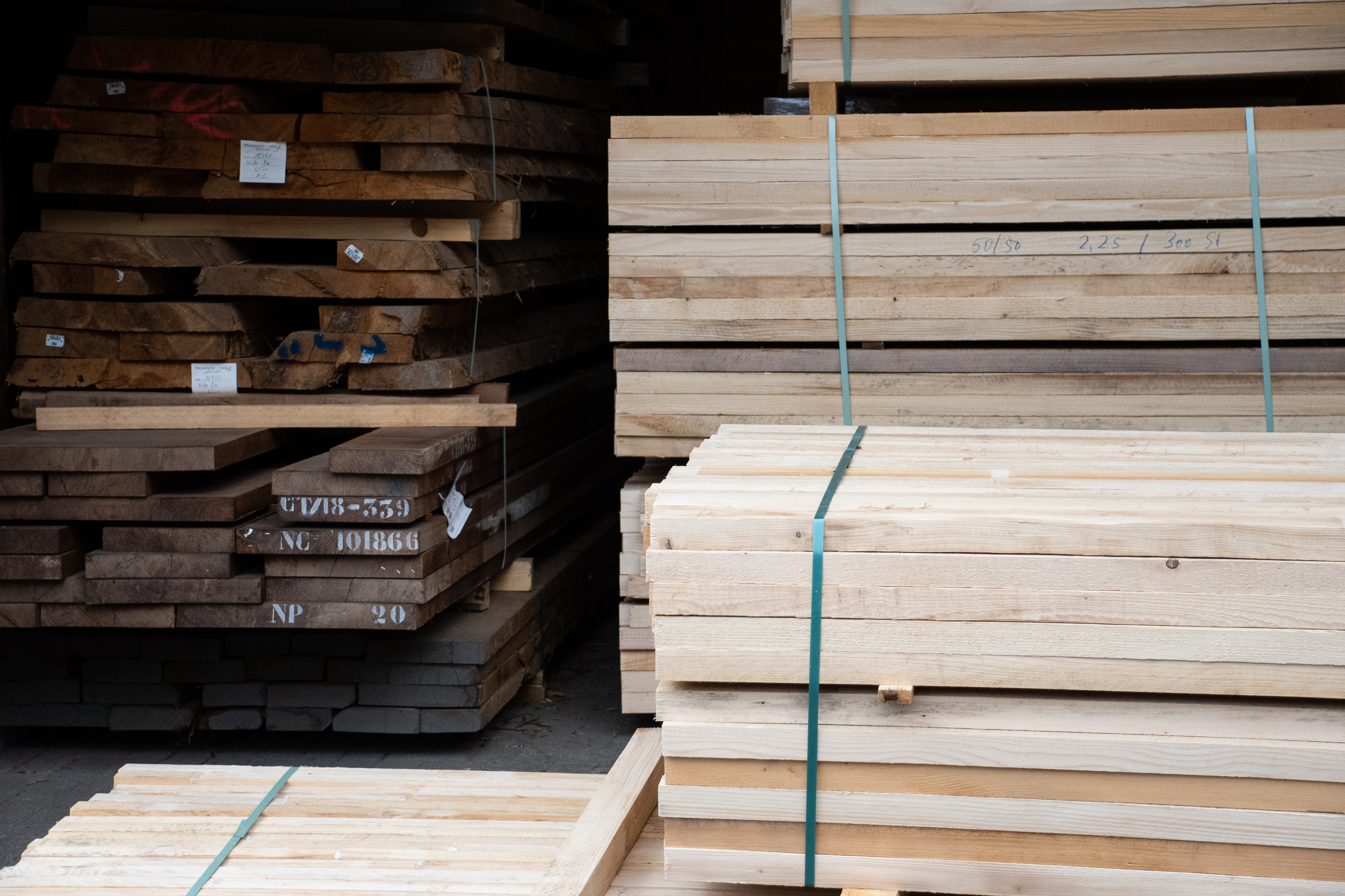 Stock de bois avec madriers en bois massif empilés et planches claires en paquets, matière première des mains courantes